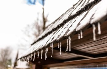 hanging-icicles-from-the-roof-of-a-wooden-building-2023-11-27-05-01-18-utc